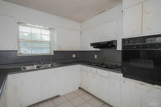 a kitchen with granite countertop a sink and a stove