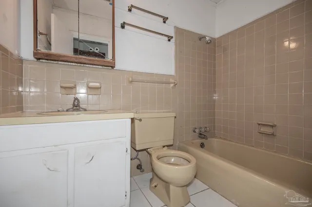 a bathroom with a toilet a sink a mirror and bathtub