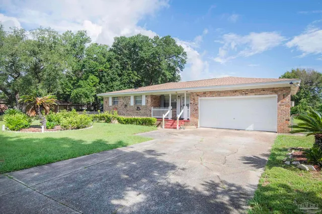 a view of a house with a yard and potted plants