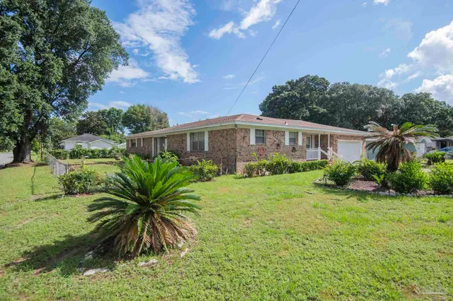 a view of a house with backyard and plants