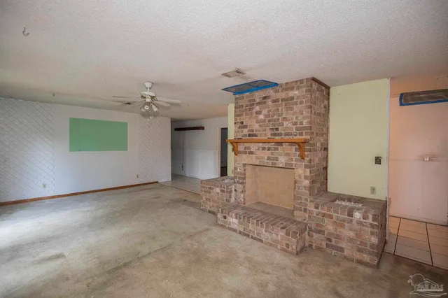 an empty room with fireplace and windows