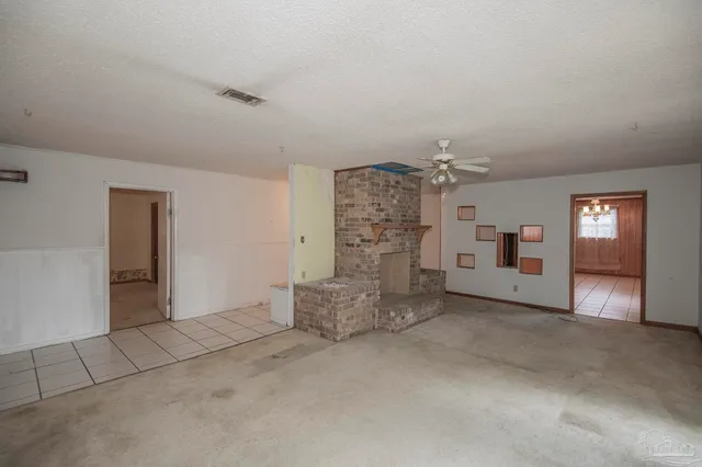 en empty room with windows and ceiling fan