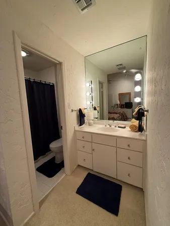 a spacious bathroom with a shower a sink and a mirror