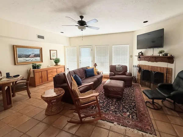 a living room with furniture a flat screen tv and a fireplace
