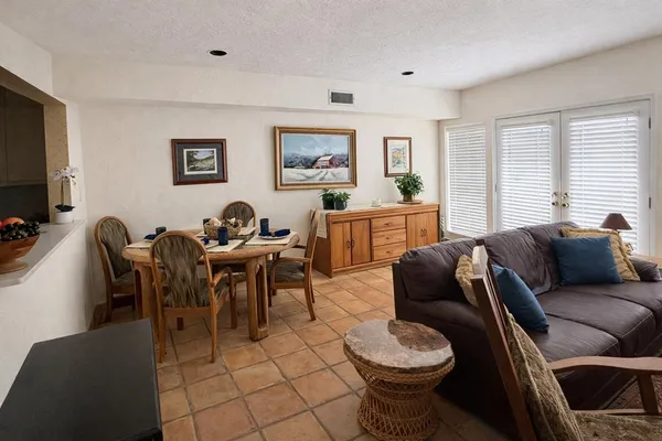 a living room with furniture a flat screen tv and a window