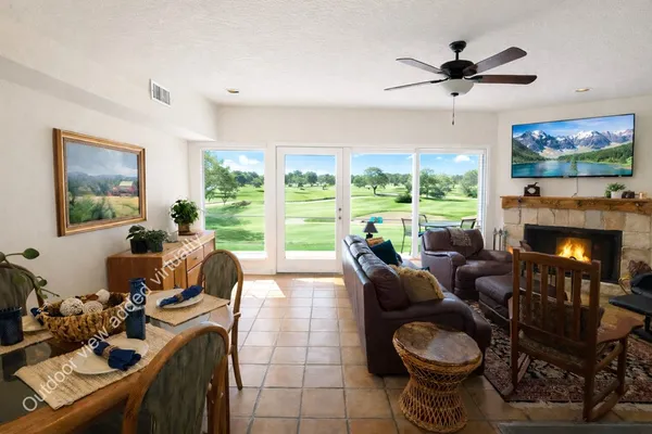 a living room with furniture a flat screen tv and a large window