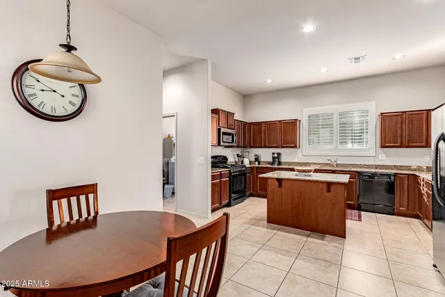 a kitchen with stainless steel appliances granite countertop a sink a counter space and living room