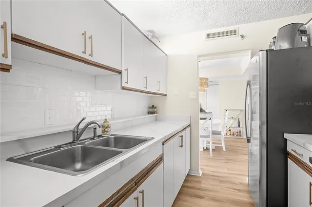 a kitchen with a sink and refrigerator