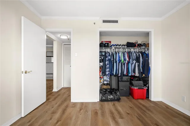 a view of a hallway with wooden floor and closet