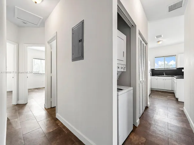 a view of a hallway with a dining table and chairs