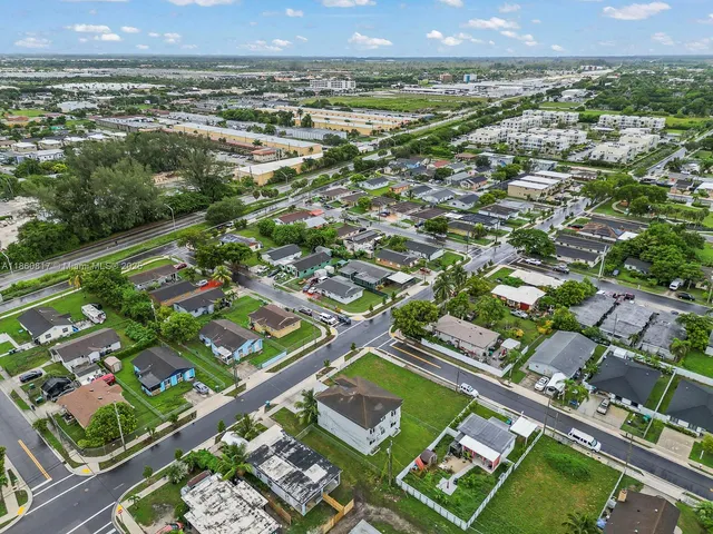 an aerial view of residential houses with outdoor space and street view