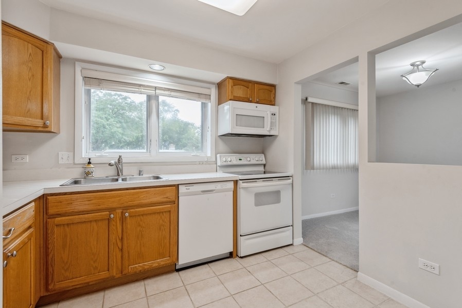 435 Ridge Road, Unit 305 Wilmette, IL 60091 - Photo 4 of 10 a kitchen with granite countertop a sink and white cabinets