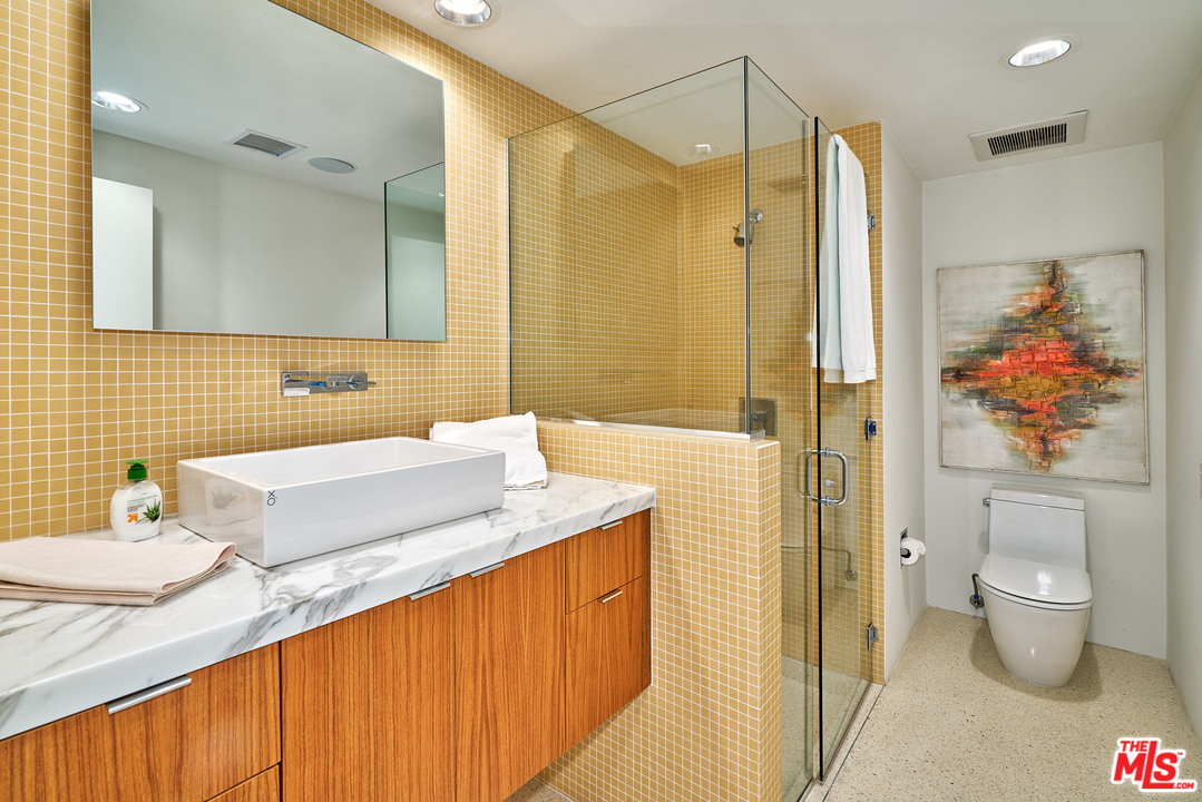 70411 Pecos Road Rancho Mirage, CA 92270 - Photo 26 of 40 a bathroom with a granite countertop sink a toilet a mirror and shower