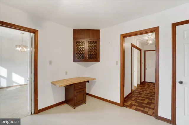 a view of an empty room with chandelier fan and a window