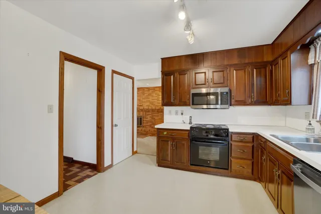 a view of an empty room with window and ceiling fan