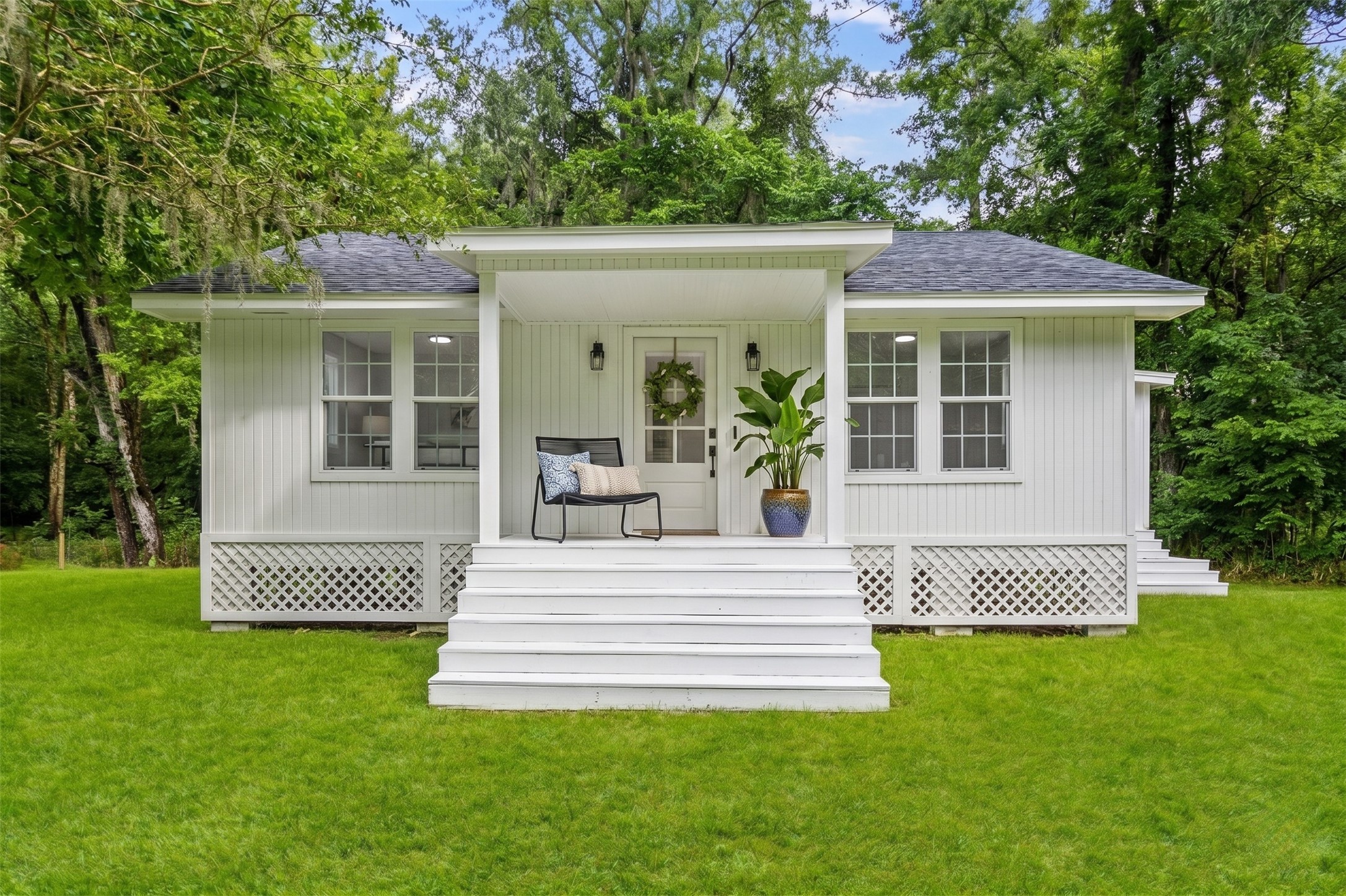 The charming covered front porch welcomes you with peaceful views and is the perfect spot to enjoy your morning coffee or unwind after a day on the lake. *digitally enhanced