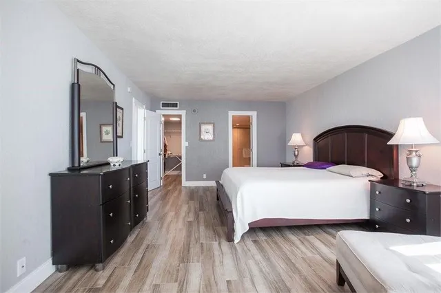 a bedroom with a bed and a flat tv screen on a dresser