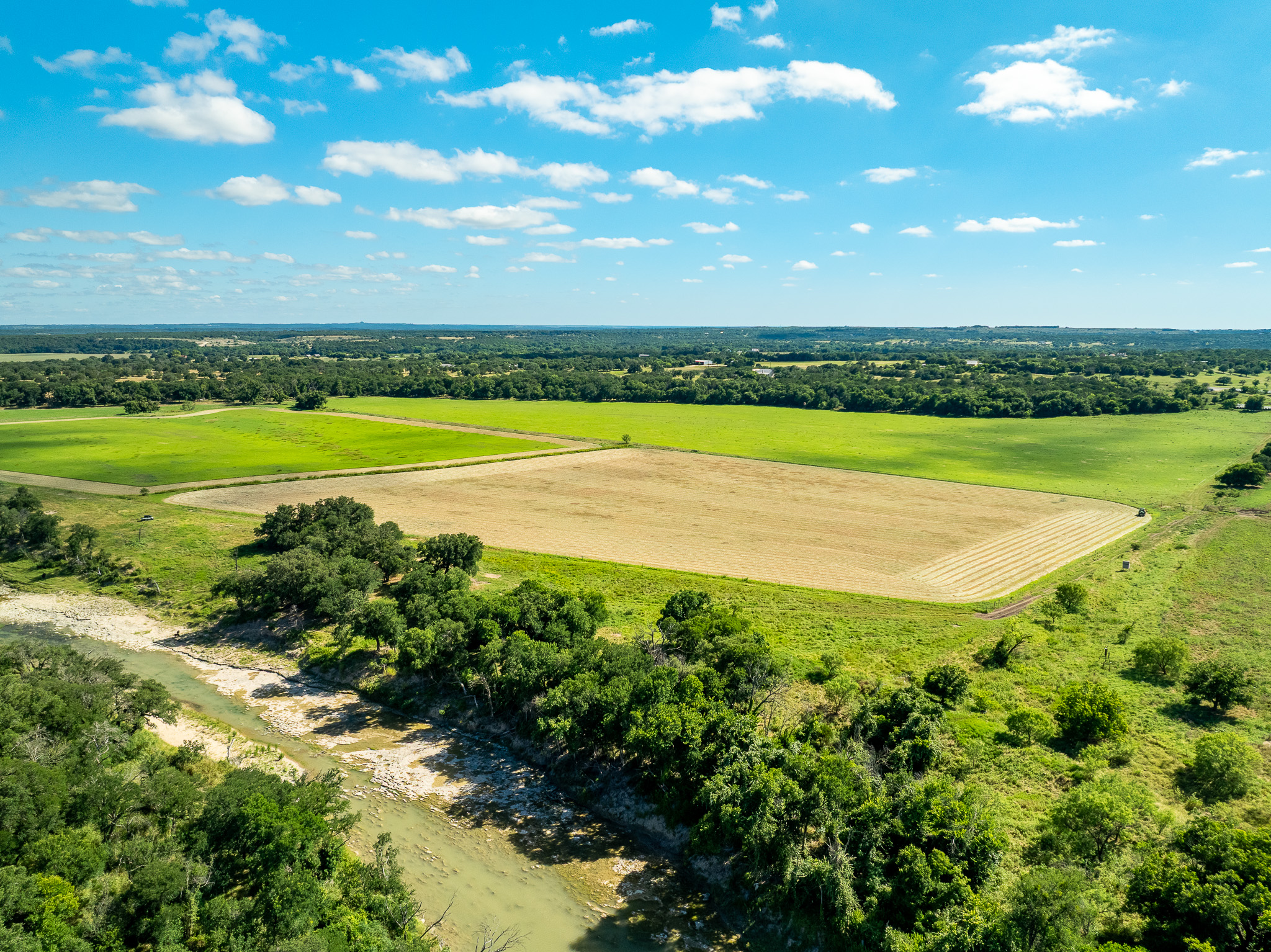 8044 580th Street East Kempner, TX 76539 - Photo 27 of 40 Sprawling acreage with vibrant green fields, a meandering stream, and expansive blue skies perfect for a tranquil retreat.