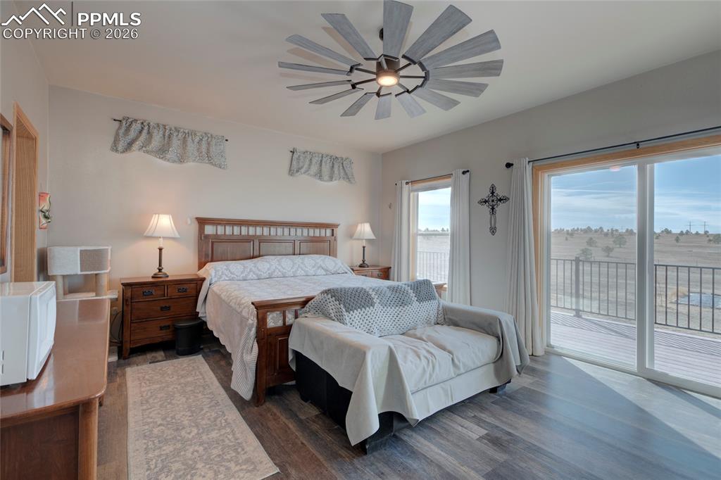 24965 Cave Spg Trail Elbert, CO 80106 - Photo 16 of 50 a bedroom with a large bed and a chandelier