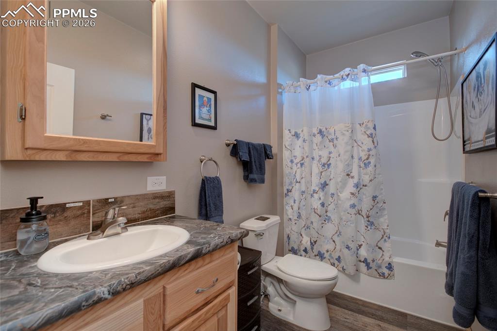 24965 Cave Spg Trail Elbert, CO 80106 - Photo 19 of 50 a bathroom with a granite countertop sink toilet and a shower