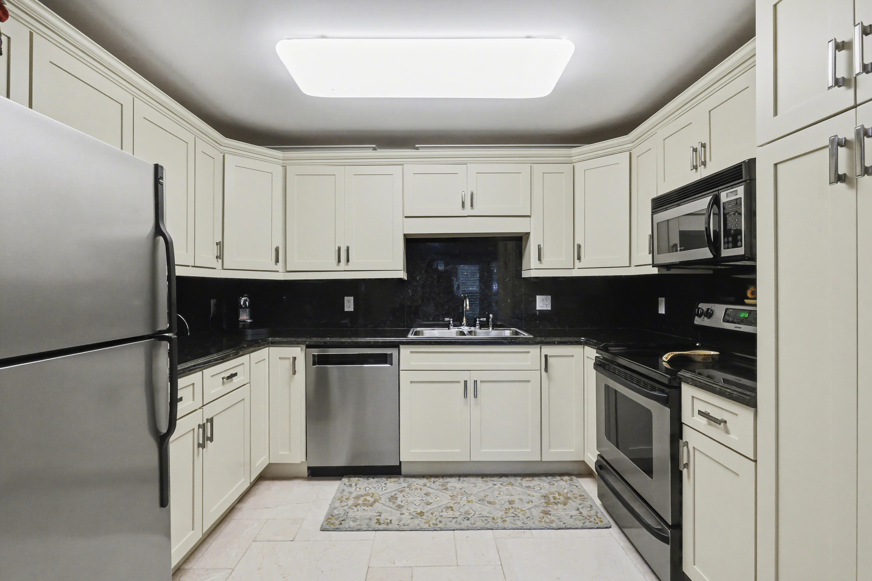129 South Golfview Road, Unit 2 Lake Worth Beach, FL 33460 - Photo 14 of 35 a kitchen with white cabinets and appliances