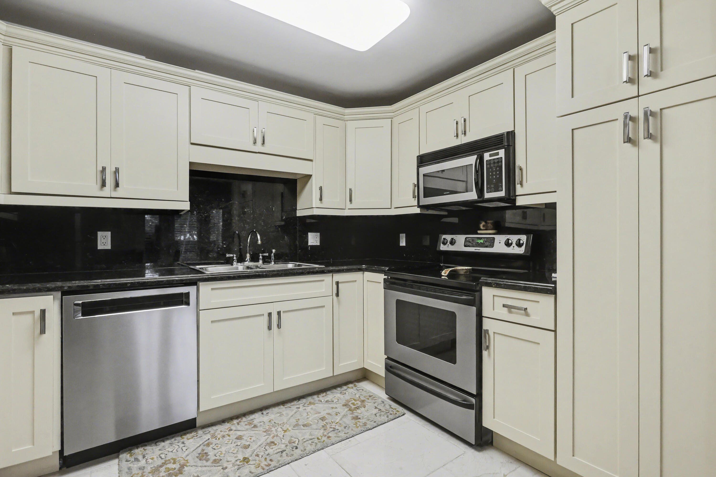 129 South Golfview Road, Unit 2 Lake Worth Beach, FL 33460 - Photo 15 of 35 a kitchen with stainless steel appliances granite countertop grey cabinets a stove a sink and dishwasher