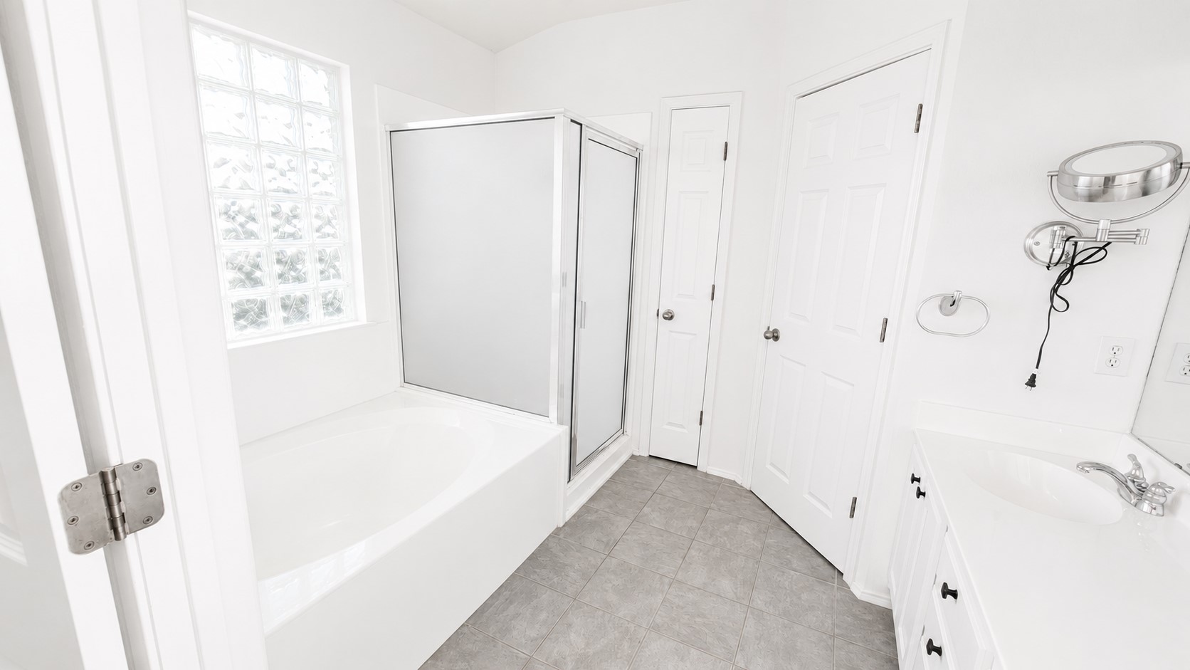10528 Dunham Forest Road Austin, TX 78717 - Photo 8 of 12 Modern bathroom features a deep soaking tub and a sleek glass-enclosed shower.
