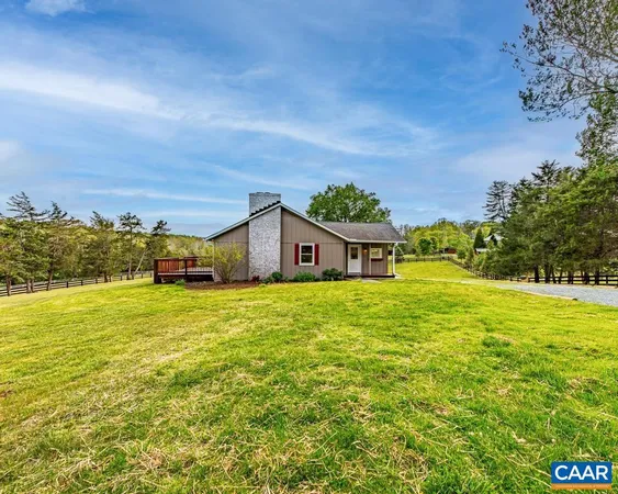a front view of house with yard and ocean