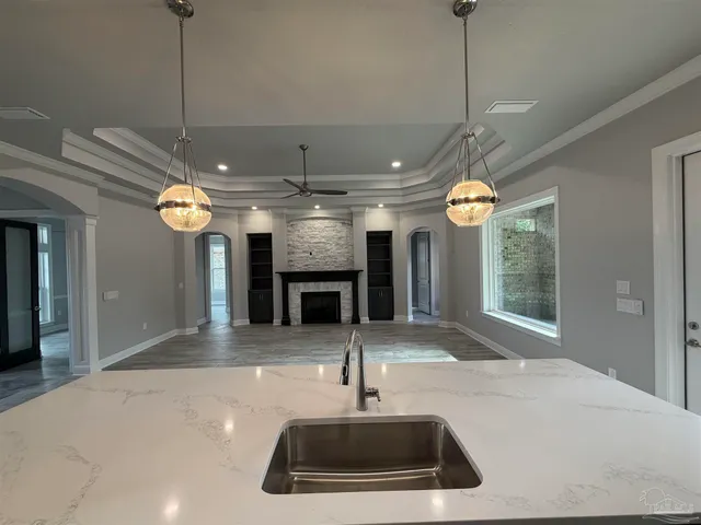 a kitchen with a sink a counter space appliances and cabinets