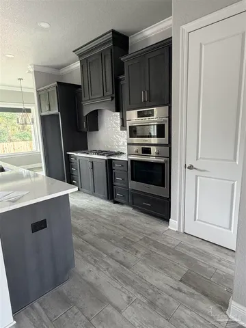 a kitchen with stainless steel appliances a stove a refrigerator and a sink