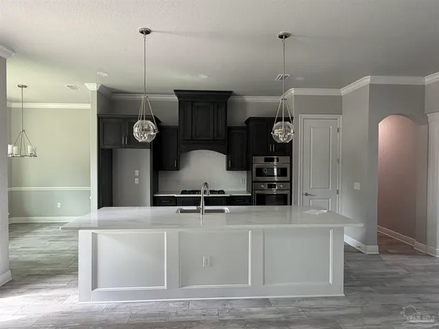 a kitchen with stainless steel appliances granite countertop a sink a refrigerator and a stove