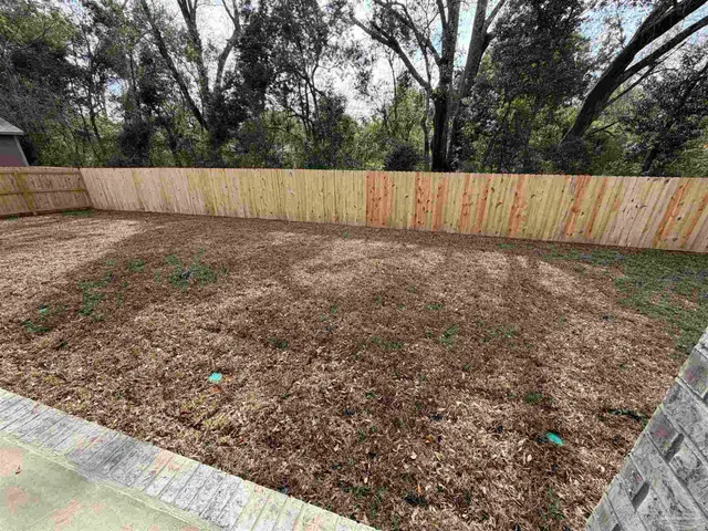 a view of garden with wooden fence