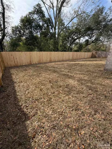 a view of a barn with white wall and wooden fence