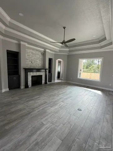 a view of an empty room with a fireplace and a window