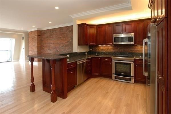 a kitchen with stainless steel appliances granite countertop a stove a sink and a microwave