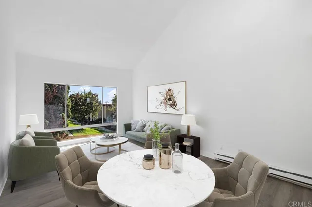 a dining room with furniture and a large window