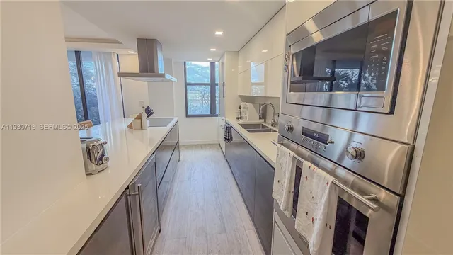 a kitchen with kitchen island wooden floor and refrigerator