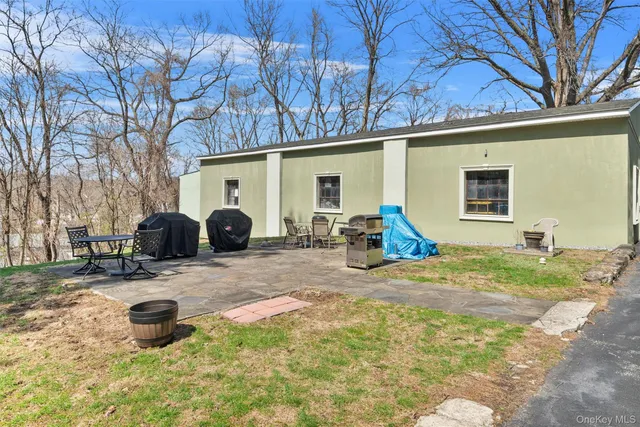 a backyard of a house with barbeque oven and outdoor seating