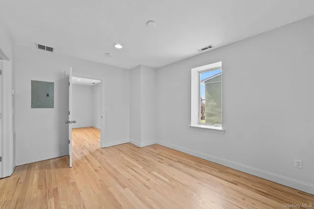 a view of a room with wooden floor and a window