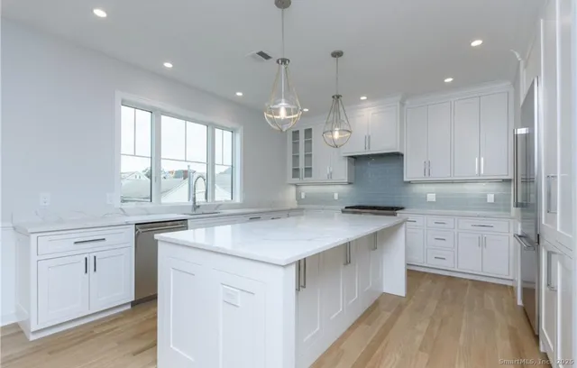 a kitchen with a white stove cabinets and a chandelier