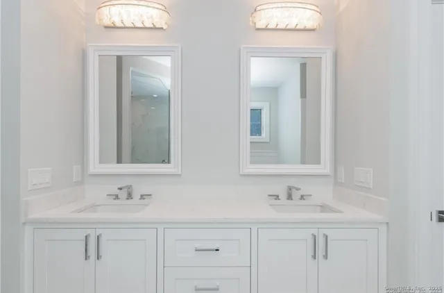 a bathroom with double sink and a mirror