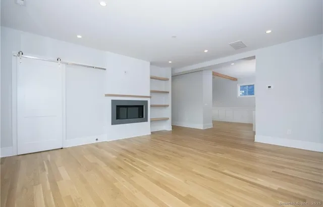 a view of empty room with wooden floor and fireplace
