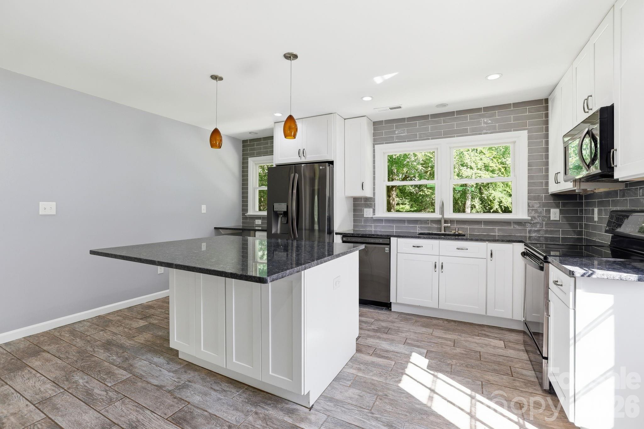 1108 Willoughby Road Monroe, NC 28110 - Photo 15 of 48 a kitchen with stainless steel appliances kitchen island granite countertop a sink and a stove