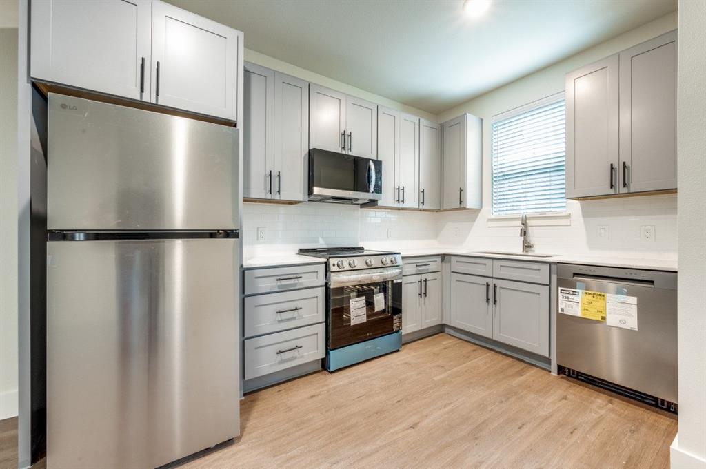 5317 Reiger Avenue, Unit 202 Dallas, TX 75214 - Photo 6 of 12 a kitchen with stainless steel appliances granite countertop a refrigerator a stove a sink and a microwave