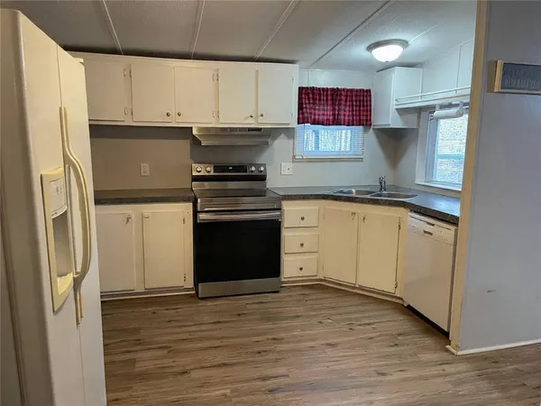 a kitchen with stainless steel appliances granite countertop a refrigerator sink and stove