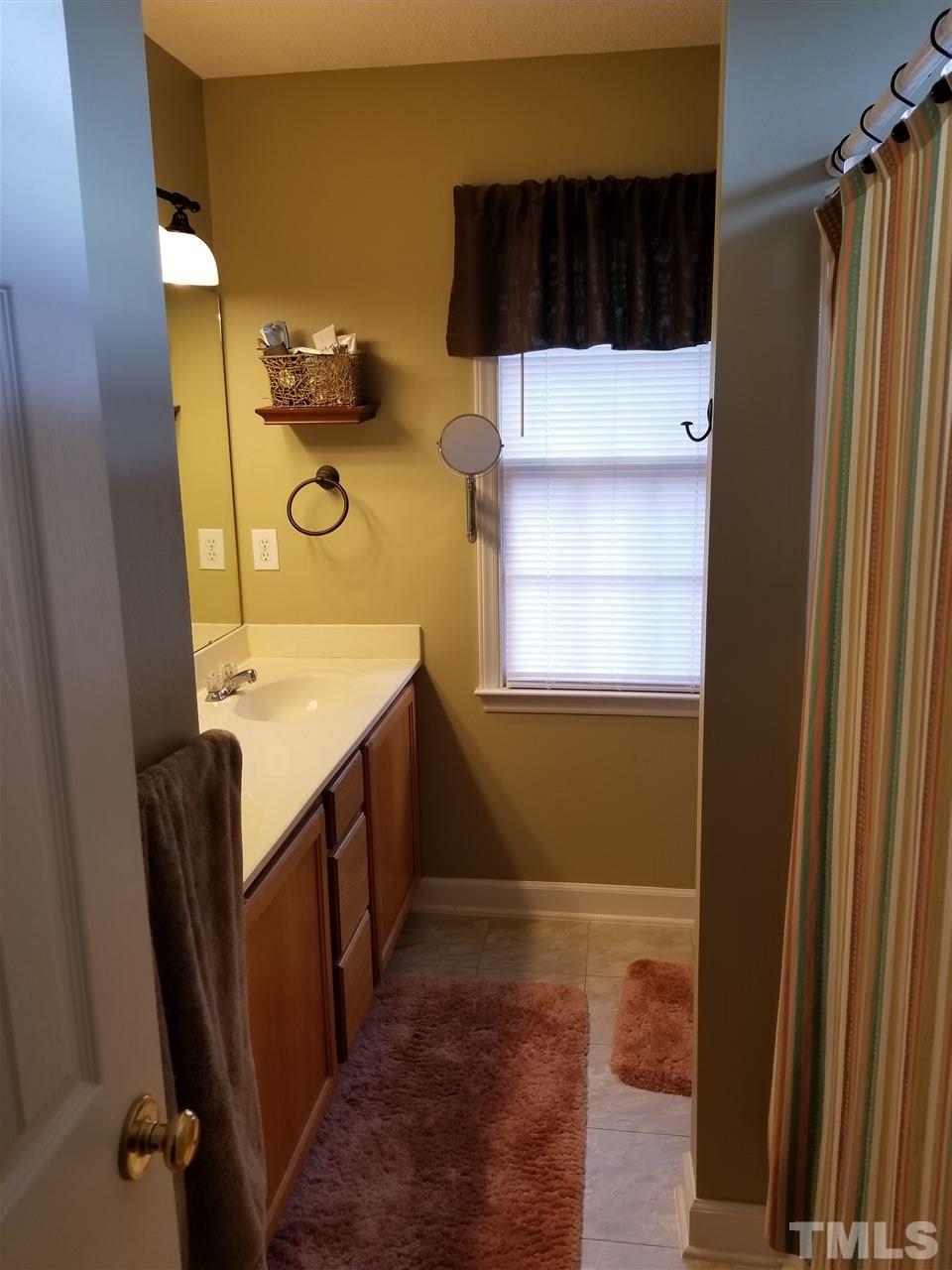 4405 Willow Lake Road Raleigh, NC 27616 - Photo 22 of 25 a bathroom with a sink a mirror and a shower