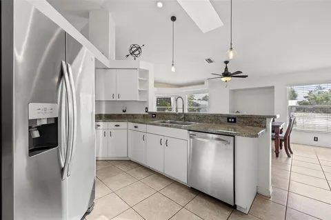 a kitchen with stainless steel appliances granite countertop a sink and a refrigerator