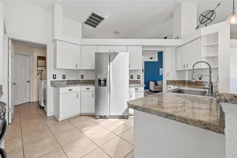 a kitchen with stainless steel appliances granite countertop a refrigerator sink and white cabinets