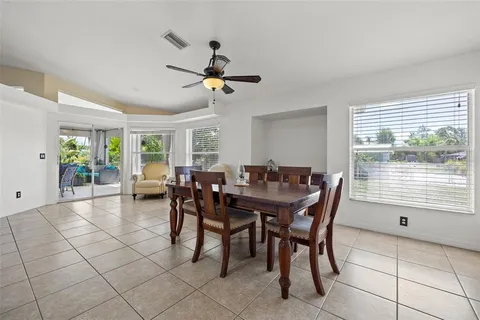 a view of a dining room and livingroom with furniture a floor to ceiling window and a flat screen tv