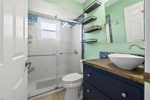 a bathroom with a granite countertop sink toilet and shower